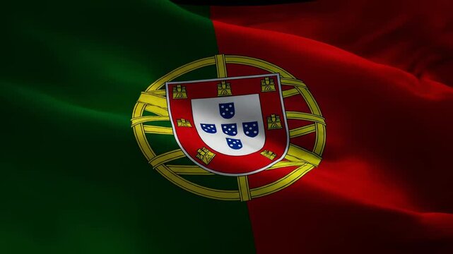 Close-up view of the national flag of Portugal waving gently, showcasing its green and red bicolour design with the armillary sphere and shield emblem.