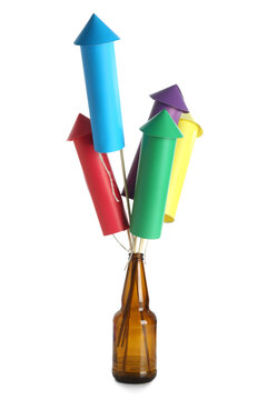 Bottle with colorful firework rockets on white background