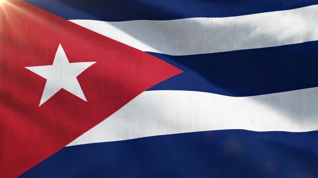 Close up waving Cuban flag with a bright white star on a red triangle and blue and white stripes, illuminated by sunlight.