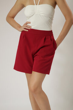 Fashion Model in White Tie-Front Halterneck Tube Top and Red Tailored Shorts &ndash; Stylish Summer Studio Fashion Concept