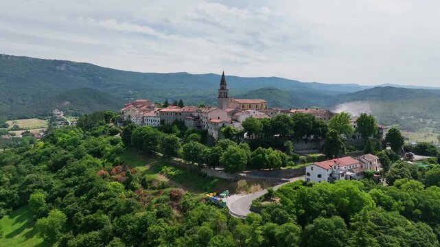 erial drone view of Buzet historic medieval town in Istria Croatia at early summer showing old stone buildings, hilltop settlement, surrounding forests and green valley landscape