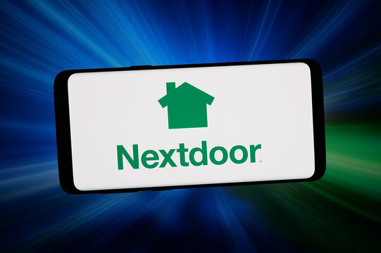 Stuttgart, Germany - 03-09-2026: In this photo illustration, the logo of social media company Nextdoor Holdings Inc. is displayed on a smartphone in front of abstract background on computer screen.