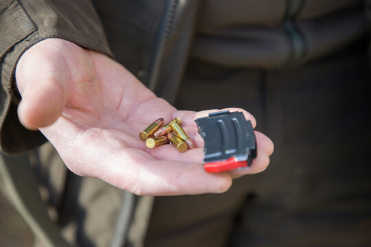 Close-up of a man loading a carbine with 22 LR cartridges