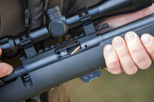 Close-up of a man loading a carbine with 22 LR cartridges
