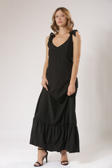 Fototapeta premium Fashion Model in Black Sleeveless Maxi Dress With V-Neck – Stylish Summer Fashion and Elegant Studio Concept