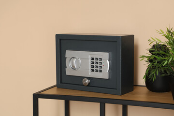 Modern safe on shelf near beige wall, closeup