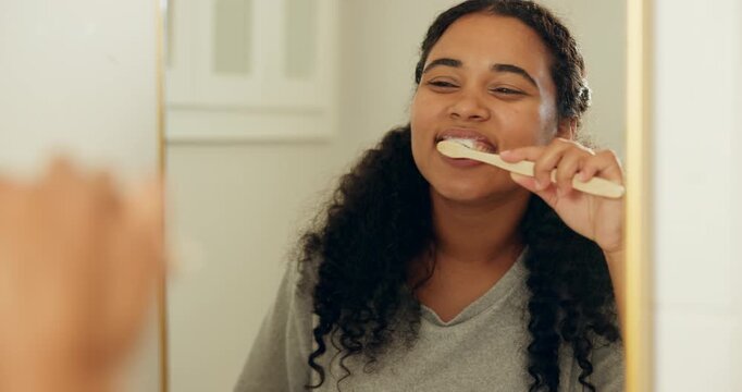 Brushing teeth, mirror and woman in home, oral hygiene and morning routine for self care. Dental health, reflection or person in bathroom, toothpaste or cleaning mouth for wellness or remove bacteria