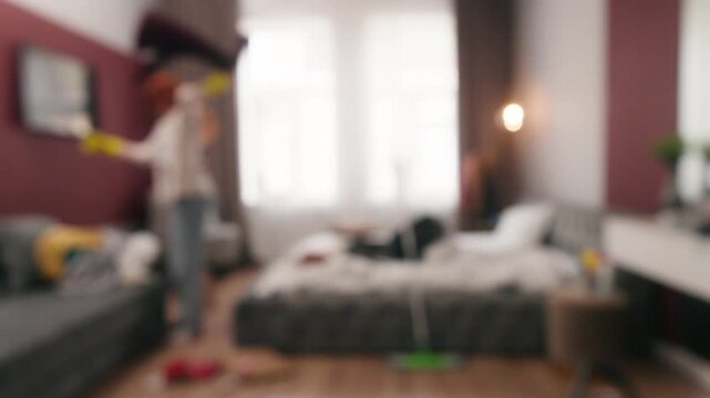 Blurry view woman cleaning home unfocused girl throwing cloth in house blurred female busy irritated with domestic cleanup housekeeping stress housewife maid cleaner mess in bedroom throw clothes