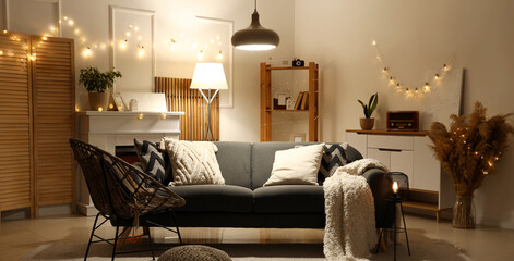 Naklejka premium Interior of living room with sofa, armchair and glowing lights in evening