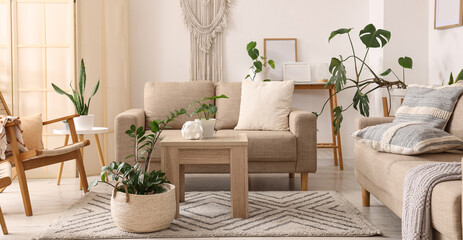 Interior of light living room with green plants, sofas and tables © Pixel-Shot
