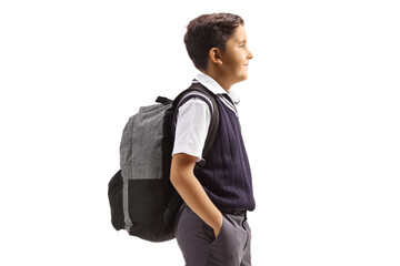 Profile shot of a schoolboy in a uniform standing with hands inside pockets