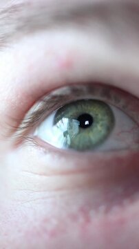 Vertical screen human eye reflecting social media content on smartphone illustrating dopamine driven engagement endless scrolling and psychological reward loop in modern digital platforms