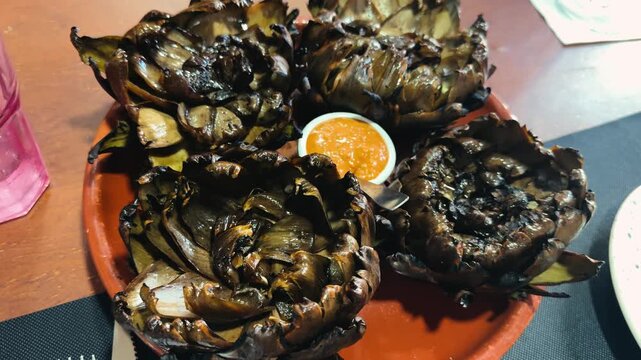 Grilled alcachofa, artichoke with romesco sauce, a traditional dish of Catalan cuisine.