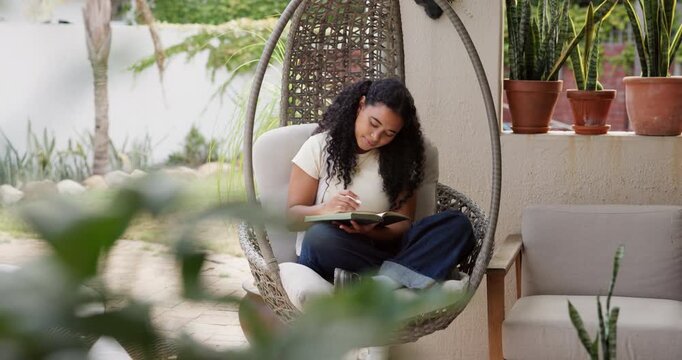 Diary, notebook and woman on hanging chair outdoor with agenda, feelings or emotions with writing. Mental health, relax and female person with journal with to do list, personal growth or self care.