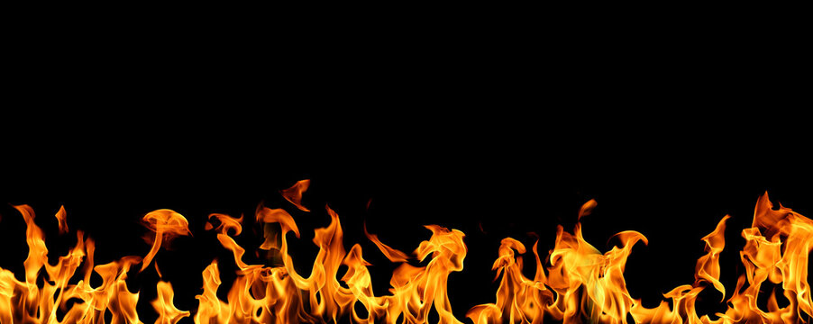 Bright orange fire flames burning in a horizontal line isolated on black background, realistic heat energy blaze with dynamic flame shapes and glowing light. Abstract fire border for danger, power.
