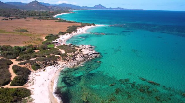 4K Aerial View of Costa Rei Rugged Coastline in Sardinia. Cinematic Flight over Turquoise tropical Sea White Sandy Beaches and Granite Cliffs. Scenic Mediterranean Landscape Italy. High Quality Video.