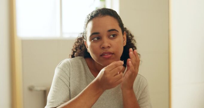 Mirror, woman and pimple patch in bathroom with skincare, blemish control and hydrocolloid benefits. Person, reflection and apply zit sticker in home for acne treatment, face breakout or dermatology.