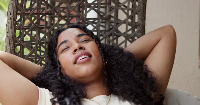 Thinking, woman and relax in hanging chair in front yard for chill weekend, comfort and calm morning. Home, african girl and stretch on patio seat for rest, self reflection and peaceful satisfaction