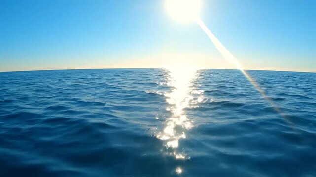Video of sunlight reflection on ocean with bright glare sweep and gently curved horizon, serene seascape background for travel and nature branding.