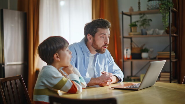 Dad boy enjoy webchat communication sitting kitchen closeup. Father son talking