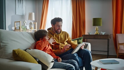 Fototapeta premium Father boy video calling talking tablet web camera sitting home couch closeup.