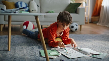 Preteen boy learning homework in living room closeup. Smart pupil reading task  © stockbusters
