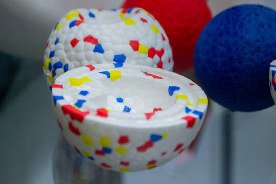 Example object from material expanded polypropylene EPP, universal foam. Durable foam white dog ball toy close-up. Shape of connected balls, multi-colored pattern. New modern industrial technologies.