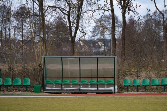 Green plastic seats on a substitute bench at a local sports stadium