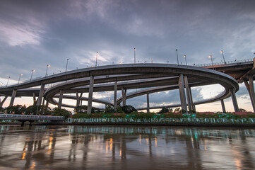 View of the Bhumibol Bridge, also known as the Industrial Ring Road, during sunset. This iconic structure connects Bangkok and Samut Prakan by spanning the Chao Phraya River twice.