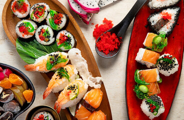 A table with Asian food, sushi, rolls, desserts. © bit24