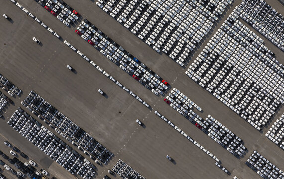 Aerial view of cars neatly arranged in rows, creating a mesmerizing pattern of white and grey, punctuated by occasional splashes of color, Shanghai, Shanghai, China.