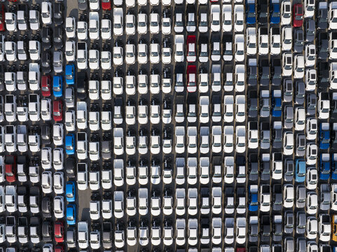 Aerial view of tightly packed cars form a patterned mosaic of gleaming white, punctuated by vibrant reds and blues, Shanghai, Shanghai, China.