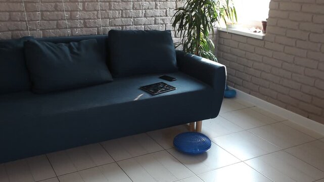 a tablet and a smartphone are lying on the sofa in the room