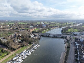 Fototapeta premium Hampton Court road bridge over Thames Surrey UK drone,aerial boats moored on river bank