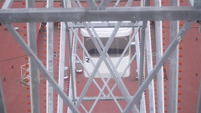 Narrow light steel load bearing structure of Ferris wheel during operation. Cross bracing steel struts ensuring safety and holding framework of large attraction during circular movement.