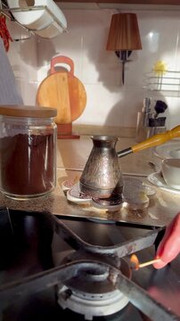 Placing Traditional Turkish Coffee Cezve on Gas Stove Burner During Home Coffee Brewing