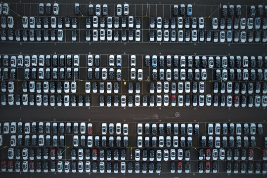 Aerial view of neatly arranged vehicles in orderly rows creates a geometric tapestry of monochrome shades broken by the occasional splash of color, Stone, England, United Kingdom.