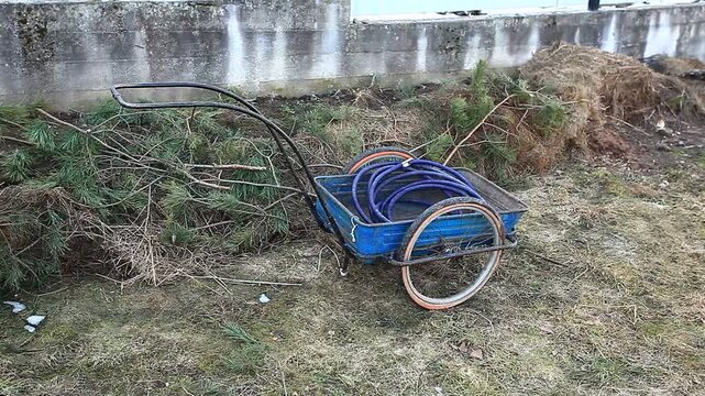 A metal garden cart on a lawn in spring