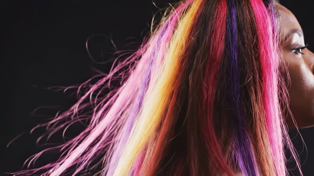 Woman with vibrant, multicolored hair flowing dynamically in motion