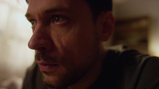 Close up of distressed adult man experienced trauma flashback while sitting in dimly lit bedroom, copy space