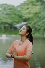 Young asian woman practicing yoga on nature. Girl meditating outdoors. Female with slim, strength and flexibility body. Healthy lifestyle. Vitality, calmness, relax, mindfulness and zen energy concept