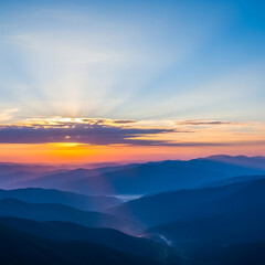 Obraz premium Breathtaking mountain ranges unfold under a vibrant sunrise sky with layers of morning mist.