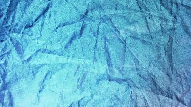 Green and blue hues shimmer across its folds. Light catches edges,