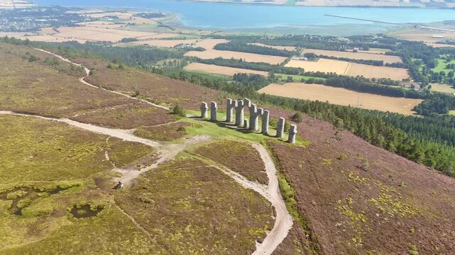 Cinematic Drone Aerial View of Fyrish Monument with Purple Heather in Bloom, Historic Stone Arches on Fyrish Hill Overlooking Cromarty Firth, Scottish Highlands Landscape, Evanton, Scotland, UK.