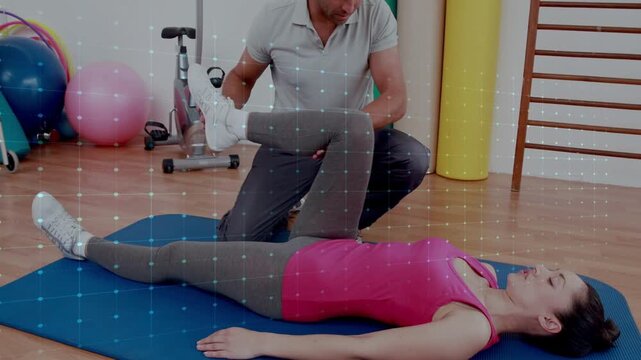 Trainer kneeling, grasping ankle and starting hip flexion for rehab on blue mat, waveform overlay
