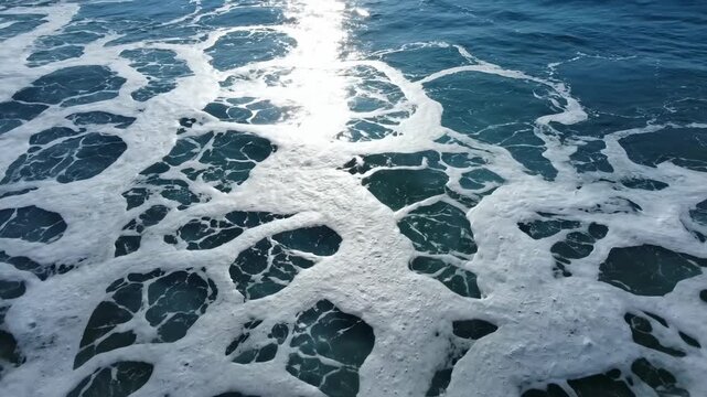 Video of Ocean Foam Top View \'96 White waves creating abstract texture, natural sea pattern background, coastal water surface, tranquil marine concept for modern branding and digital media.
