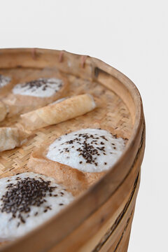 Steamed solo serabi served with coconut and chocolate sprinkles in a bamboo basket.