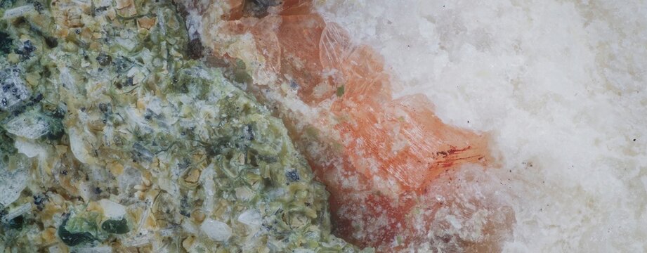 Macro: Heulandite white cream granular formations with stilbite orange fibrous aggregates and chlorite green fan-shaped crystals from Vivi River, Evenkia, Russia, 12x magnification, 3mm field