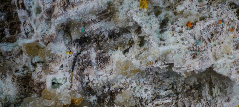 Macro image of pyromorphite yellow granular, phosphohedyphane white gray, aurichalcite green from Murzinsky Mine, Altai Krai, Russia, via microscope, 10x magnification, 3.6mm field of view