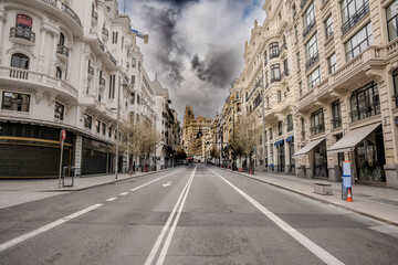 Calle Gran Vía de Madrid vacía bajo un cielo tormentoso, arquitectura clásica europea